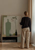 Tableau de nature morte minimaliste avec bouteilles élancées, verre transparent, branche aux feuilles sombres, petits fruits rouges et tons vert sauge, beige, noir et gris, dans un style épuré et équilibré. Disponible sur kudeko.com