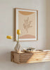 Gerahmtes Wandbild mit Blattzweig in brauner Linienzeichnung auf beigem Hintergrund, organischen Formen in Sand und sanftem Terrakotta, minimalistisch und natürlich gestaltet. Erhältlich auf kudeko.com