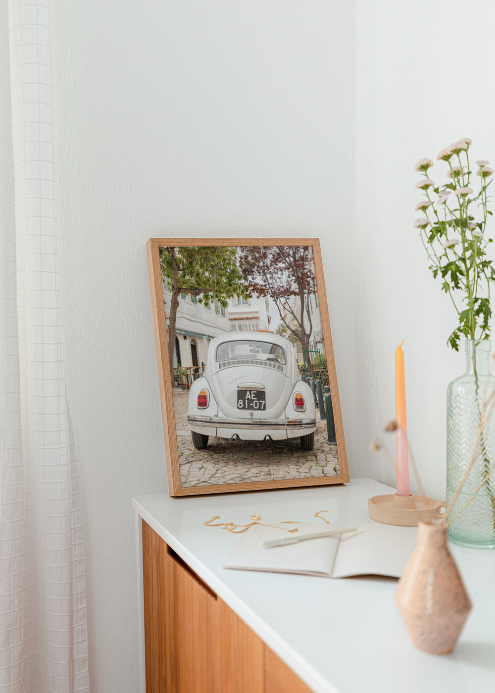 Tableau représentant une voiture classique blanche dans une rue pavée, avec arbres verts, façades claires et ambiance méditerranéenne, dans un style photographique vintage. Disponible sur kudeko.com