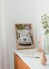 Cuadro decorativo de estilo minimalista y sereno colocado en salón, fotografía vintage de coche clásico en calle europea, modelo Driving Cascais