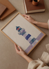 Cuadro decorativo de estilo minimalista y sereno colocado en salón, faro costero en tonos azules, modelo Faro Reflejos Azules