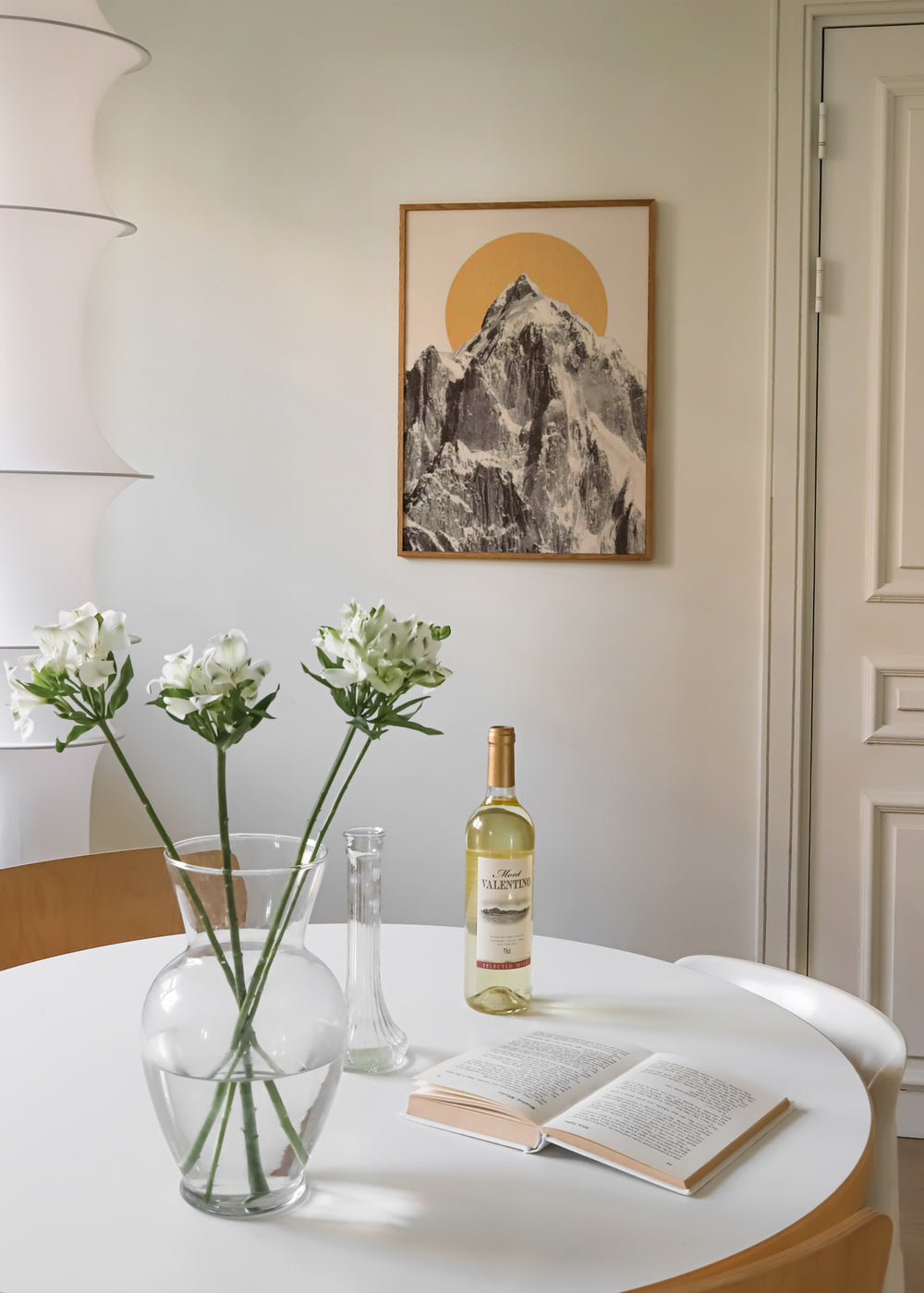 Tableau encadré avec montagne enneigée en blanc, noir et gris, soleil circulaire moutarde sur fond beige clair, dans un style nature et paysages contemporain. Disponible sur kudeko.com