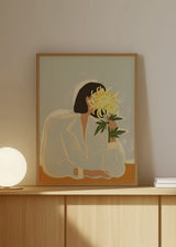 Gerahmtes Wandbild einer Frau im Profil mit gelber Chrysantheme, grünen Blättern, sanft beigem Hintergrund und ruhigem Illustrationsstil mit klaren Formen und Linien. Erhältlich auf kudeko.com