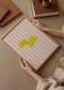Cuadro decorativo de estilo minimalista y tonos_pastel colocado en cocina, rodajas de limón sobre fondo de rayas rosas, modelo Limones Fresquitos