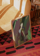 Tableau encadré avec figure humaine abstraite au centre, formes organiques en vert sauge, bordeaux, rose poudré, beige et tons terre, dans un style contemporain abstrait. Disponible sur kudeko.com