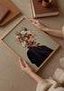 Tableau avec portrait féminin surréaliste composé de magnolias blanches, petites fleurs roses, feuilles brunes et branches fines sur fond beige, dans un style illustration délicat. Disponible sur kudeko.com