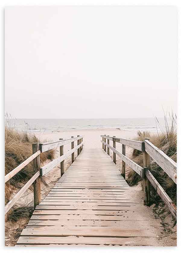Cuadro de pasarela de madera hacia la playa entre dunas, con mar sereno, cielo claro, tonos arena, beige y gris suave, de estilo fotográfico. Disponible en kudeko.com