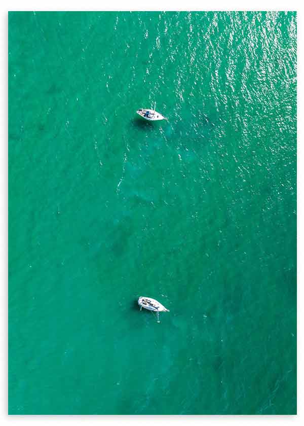 Tableau avec vue aérienne de la mer turquoise, deux petites embarcations blanches flottant sur l’eau, reflets doux et style photographique contemporain. Disponible sur kudeko.com