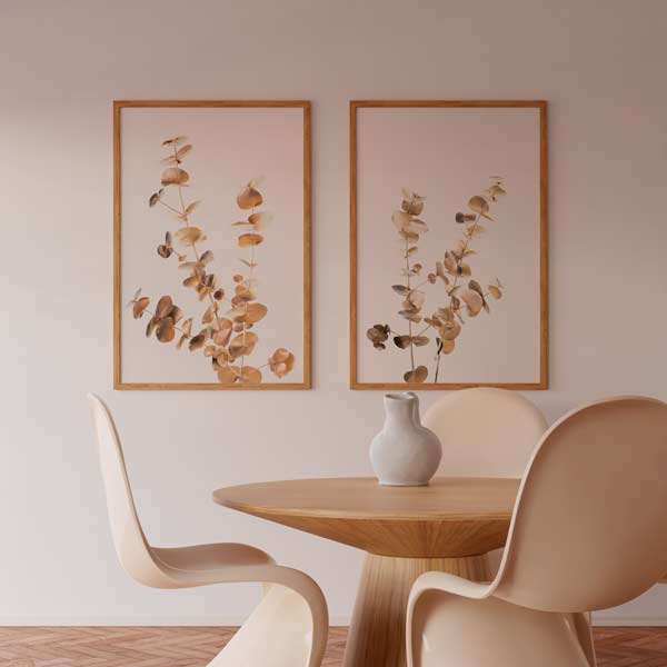 Conjunto de dos cuadros con ramas de eucalipto doradas, hojas redondeadas sobre fondo blanco, composición botánica elegante de estilo minimalista. Disponible en kudeko.com