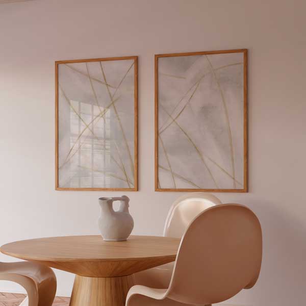 Set aus zwei gerahmten Wandbildern mit feinen goldfarbenen gekreuzten Linien auf weißem und hellgrauem Hintergrund, sanfte abstrakte Komposition im minimalistischen Stil mit neutralen Tönen. Erhältlich auf kudeko.com