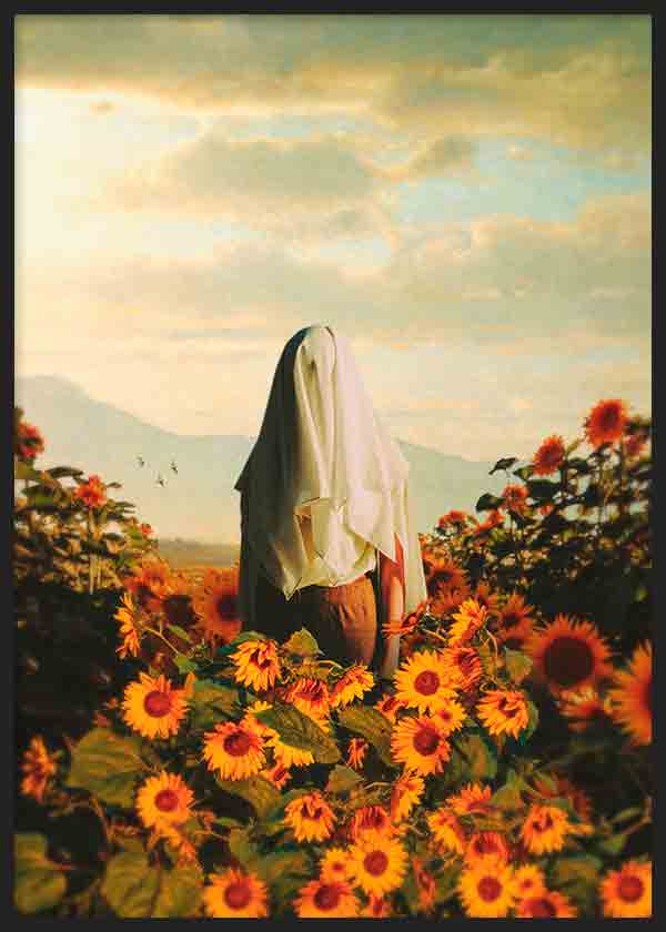 Gerahmtes Wandbild mit verhüllter Figur zwischen gelben und orangefarbenen Sonnenblumen, goldenem Himmel, sanften Bergen und fotografischem Stil. Erhältlich auf kudeko.com