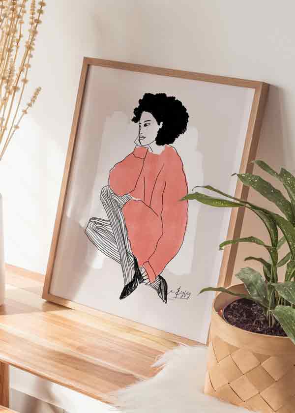 Cuadro de ilustración artística de mujer con jersey rojos sobre fondo beige. Una obra cargada de estilo.