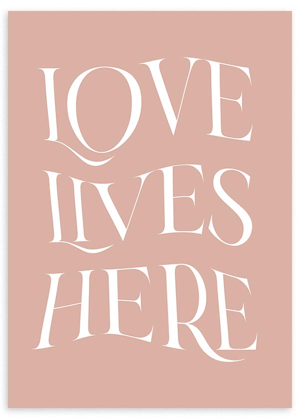 Gerahmtes Wandbild mit dem Schriftzug LOVE LIVES HERE, große weiße Buchstaben auf puderrosa Hintergrund, elegante typografische Gestaltung im dekorativen Stil mit Textmotiv. Erhältlich auf kudeko.com
