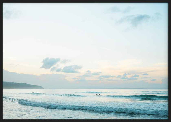 Cuadro horizontal de mar en calma al amanecer con olas suaves, cielo claro, nubes difusas, tonos azul claro y beige, de estilo fotográfico. Disponible en kudeko.com