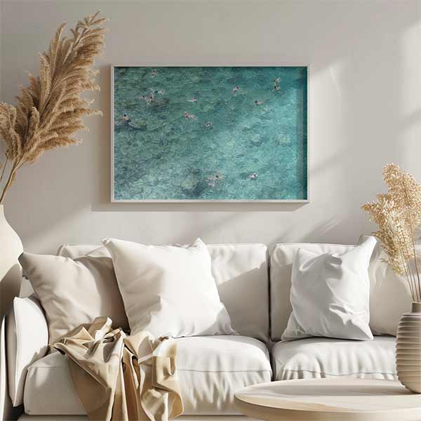 Quadro horizontal com várias pessoas a nadar em mar cristalino turquesa e água-marinha, fundo rochoso visível e estilo fotográfico com ambiente de verão mediterrânico. Disponível em kudeko.com