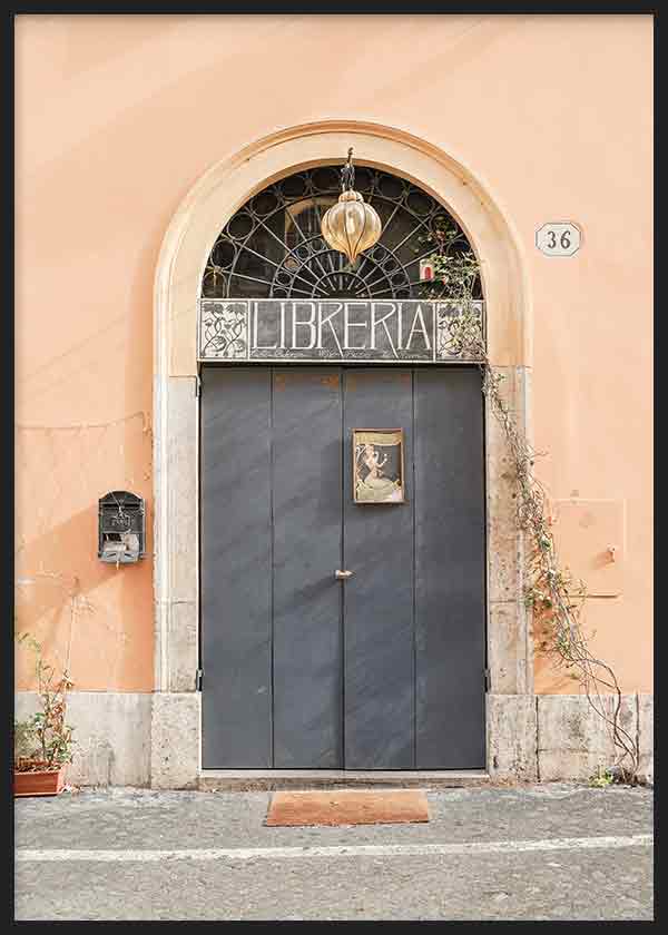 Cuadro de entrada de librería con puerta negra, arco de piedra, fachada melocotón y detalle urbano de estilo fotográfico. Disponible en kudeko.com