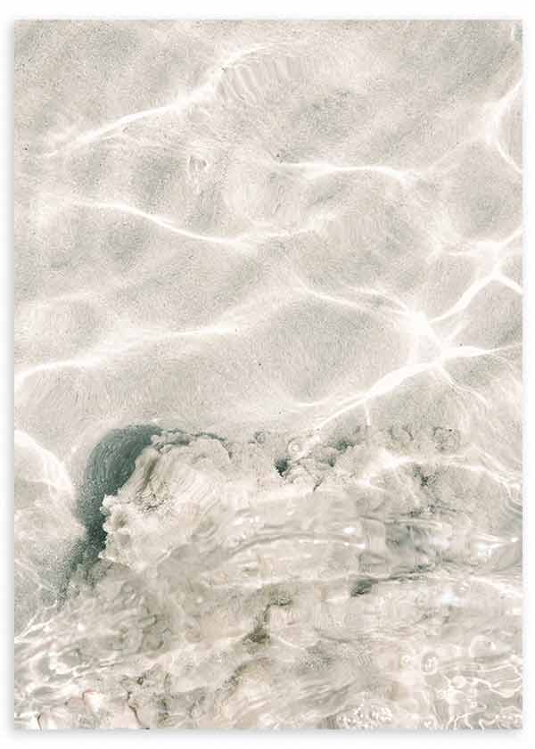 Wandbild mit kristallklarem Wasser, Lichtreflexen auf hellem Fels, in Sand, Weiß und Graugrün, mit natürlicher fotografischer Bildsprache und ruhiger Wirkung. Erhältlich auf kudeko.com