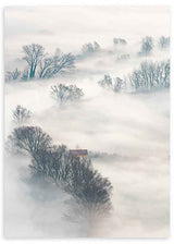 Cuadro fotográfico de bosque cubierto de niebla y casa en el centro de la imagen