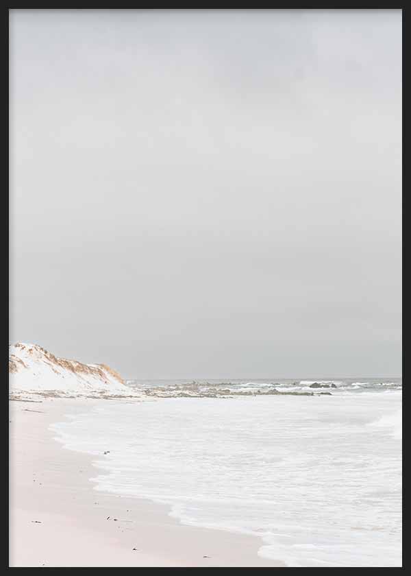 Cuadro de playa serena con orilla de arena clara, mar en tonos blancos y grises, dunas suaves y estética fotográfica vintage. Disponible en kudeko.com