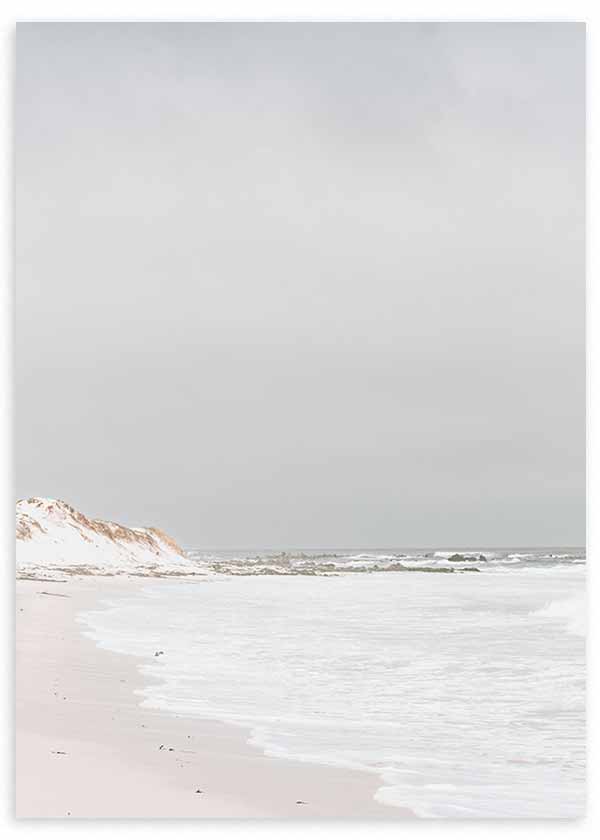 Tableau de plage paisible avec rivage de sable clair, mer aux tons blancs et gris, dunes douces et style photographique vintage, pour une décoration murale lumineuse et naturelle. Disponible sur kudeko.com