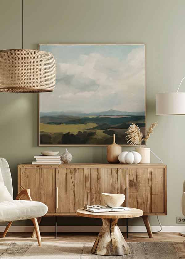 Cuadro cuadrado con paisaje de colinas difusas, campos en verde oliva y beige, cielo nuboso en azul grisáceo y estilo naturaleza y paisajes. Disponible en kudeko.com
