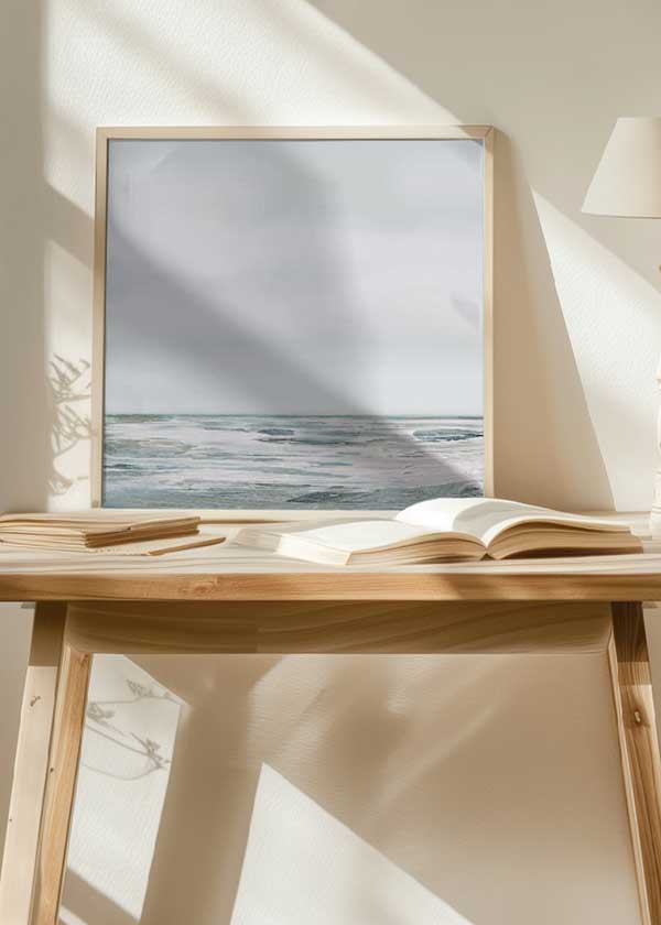 Cuadro cuadrado con paisaje marino de horizonte abierto, agua serena, rocas difusas, tonos blanco, gris perla y azul verdoso, de estilo naturaleza y paisajes. Disponible en kudeko.com