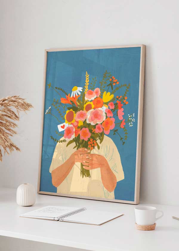 Cuadro de ilustración de mujer sobre fondo azul y ramo de flores. Una de las obras de Gigi Rosado