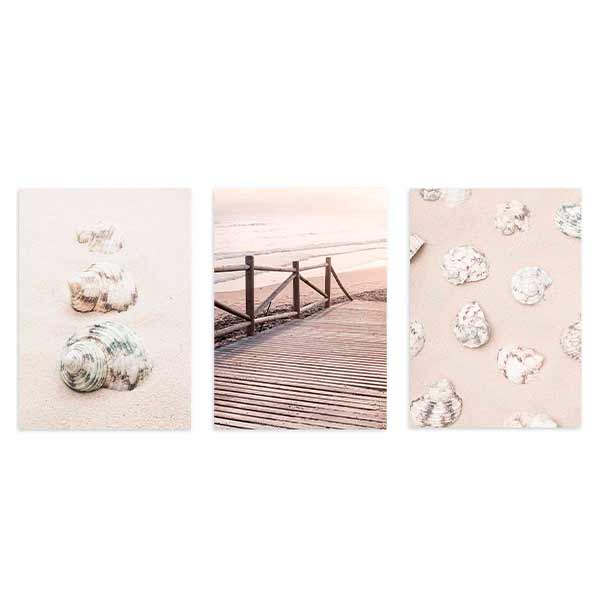 Set aus drei Wandbildern mit Muscheln am Strand, Holzsteg zum Meer, hellem Sand, Altrosa, Weiß, sanftem Beige und fotografischem Küstenstil. Erhältlich auf kudeko.com