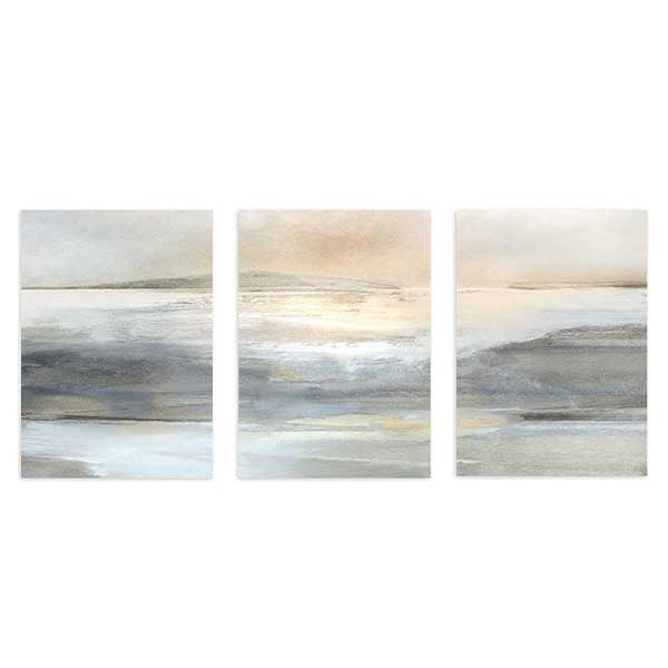 Conjunto de três quadros com paisagem abstrata, horizonte suave, água e terra em tons de bege, cinzento, branco e nuances douradas, com estilo abstrato simples e luminoso. Disponível em kudeko.com