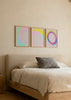 Conjunto de três quadros com formas ovais difusas em rosa, amarelo, turquesa, azul e violeta sobre fundo claro, num estilo abstrato contemporâneo e leve. Disponível em kudeko.com
