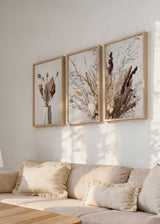 Ensemble de trois tableaux avec compositions botaniques de fleurs séchées, branches fines, épis beiges, feuilles brunes et vase clair, dans un style floral naturel et épuré. Disponible sur kudeko.com
