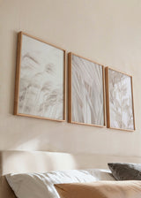 Set aus drei Wandbildern mit Blättern, Gräsern und ornamentalem Blattwerk in Beige, Sand und Elfenbein, mit sanfter botanischer Komposition im Natur- und Landschaftsstil. Erhältlich auf kudeko.com