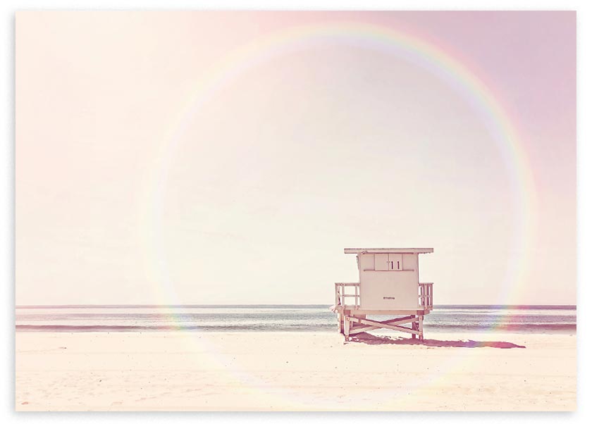 Cuadro horizontal de caseta de playa frente al mar sobre arena clara, con cielo rosa suave, tonos beige e irisados y estilo fotográfico etéreo. Disponible en kudeko.com
