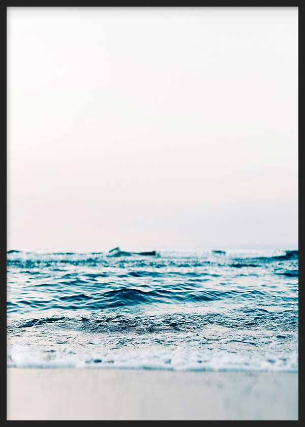 Cuadro con mar sereno, olas suaves en la orilla, arena clara, cielo luminoso y tonos azul turquesa, blanco y beige, de estilo fotográfico. Disponible en kudeko.com