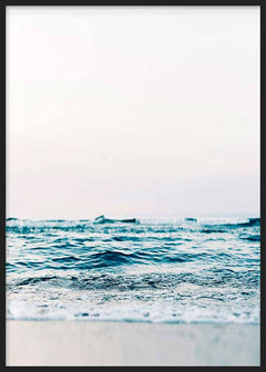 Cuadro con mar sereno, olas suaves en la orilla, arena clara, cielo luminoso y tonos azul turquesa, blanco y beige, de estilo fotográfico. Disponible en kudeko.com