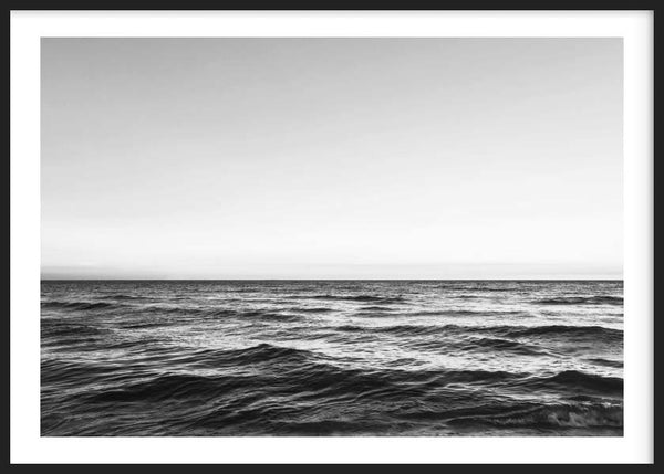 Quadro horizontal do mar a preto e branco, com horizonte limpo, ondas suaves, céu amplo e estilo fotográfico de estética serena e depurada. Disponível em kudeko.com