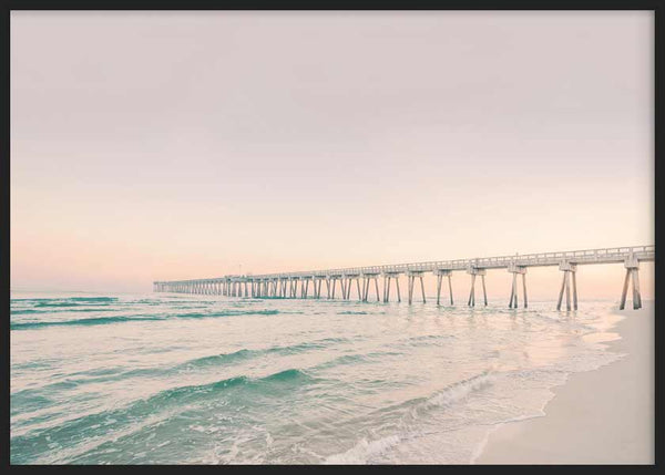 Quadro horizontal de um cais sobre o mar com ondas suaves, areia clara, céu rosado, tons turquesa e bege, em estilo fotográfico sereno. Disponível em kudeko.com