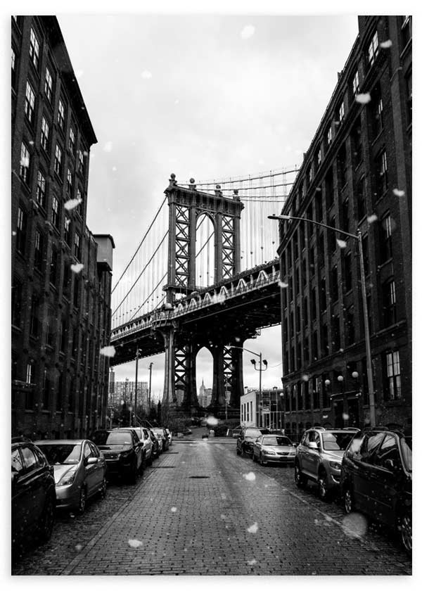 Cuadro del puente de Manhattan entre edificios de ladrillo, calle adoquinada, coches aparcados, copos de nieve y tonos blanco y negro, de estilo fotográfico. Disponible en kudeko.com