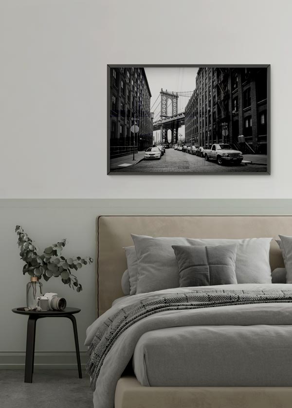 Horizontales Wandbild mit Kopfsteinpflasterstraße in Brooklyn, Manhattan Bridge, Backsteingebäuden, parkenden Autos, Schwarzweiß-Tönen und fotografischem urbanem Stil. Erhältlich auf kudeko.com