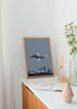 Tableau représentant un enfant sur une baleine volant parmi les étoiles, lune croissante et montagnes enneigées en tons bleu gris, style photographique poétique. Disponible sur kudeko.com