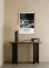 Quadro emoldurado com vista noturna de Seul, arranha-céus iluminado, grande avenida com rastos de luz, edifícios urbanos a preto e branco, estilo fotográfico elegante e cosmopolita. Disponível em kudeko.com