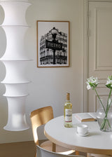 Tableau encadré avec enseigne du métro de Paris au premier plan, façade haussmannienne classique à l’arrière-plan, tons noirs, gris et blancs, style urbain photographique. Disponible sur kudeko.com