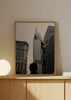 Quadro emoldurado com cena urbana de Nova Iorque a preto e branco, Empire State Building, candeeiros pretos, edifícios históricos, placa de Broadway e silhueta humana em primeiro plano, num estilo citadino contemporâneo. Disponível em kudeko.com