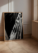 Wandbild einer Stadtstraße in Schwarz-Weiß mit gehenden Passanten, langen Schatten, Aufsichtsperspektive und fotografischem Stil mit klarem Kontrast. Erhältlich auf kudeko.com