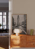 Quadro emoldurado de avenida urbana a preto e branco com edifício triangular, carros em movimento, perspetiva central e estilo fotográfico arquitetónico. Disponível em kudeko.com
