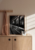Gerahmtes Wandbild mit altem Zug in Schwarz-Weiß, Frau am Fenster, Spiegelungen von Bäumen in den Scheiben und nostalgischem fotografischem Stil. Erhältlich auf kudeko.com