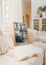Tableau encadré d’une rue parisienne en noir et blanc avec vélo, lampadaire, balcons classiques, escalier en fer forgé, façades anciennes et style photographique urbain. Disponible sur kudeko.com