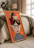 Quadro emoldurado com retrato feminino inspirado em Frida Kahlo, flores vermelhas brancas e rosa, fundo laranja e estilo de ilustração contemporânea para decoração de parede. Disponível em kudeko.com