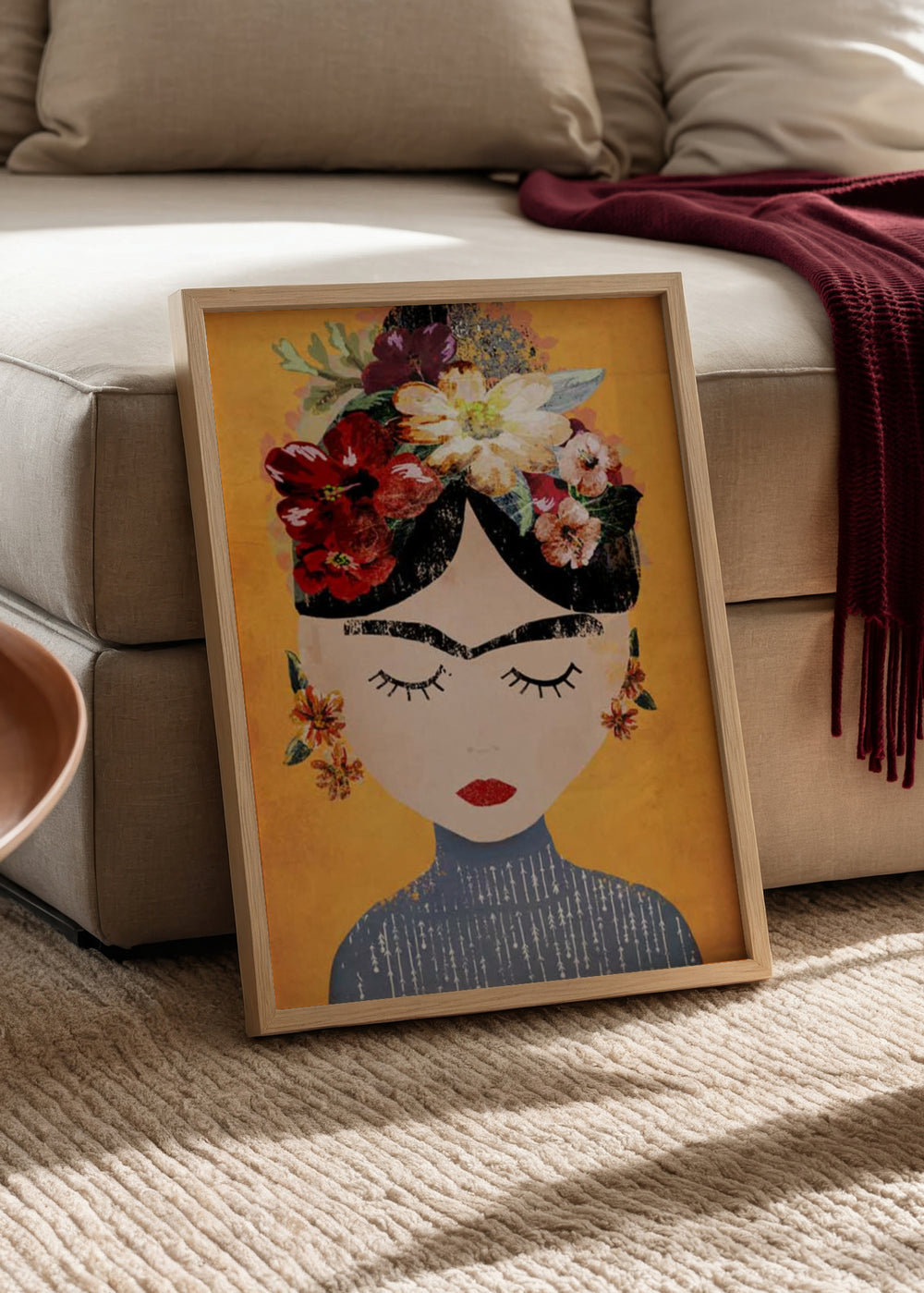 Quadro emoldurado com retrato feminino inspirado em Frida Kahlo, flores vermelhas, brancas e rosas, fundo amarelo, sobrancelhas marcadas, olhos fechados e estilo de ilustração. Disponível em kudeko.com