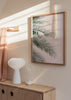 Quadro emoldurado com folhas de palmeira em tons de verde acinzentado sobre fundo rosa envelhecido, composição leve e estilo natureza e paisagem. Disponível em kudeko.com